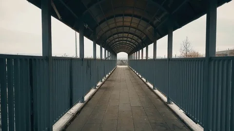Couple walking and hugging across the footbridge over highway Stock Footage 78353234