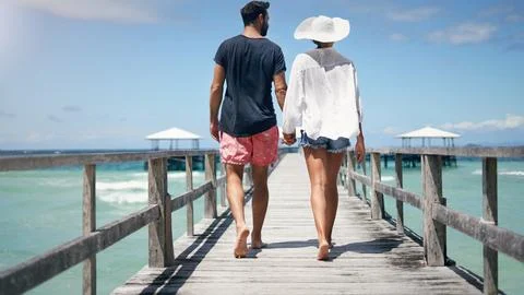 Couple, walking and Maldives pier on a tropical island on vacation with freedom Stock Photos