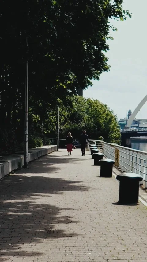 A couple walking away on a riverside path - Vertical Video Video stock 200401173