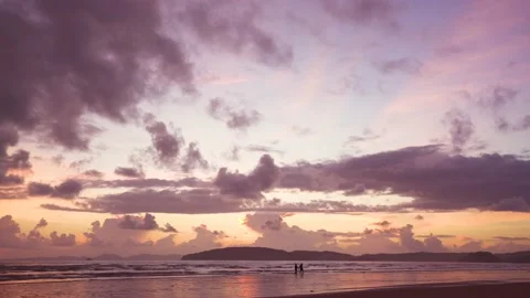 Couple walking on beach among Colorful sky after sunset Stock Footage 153507953
