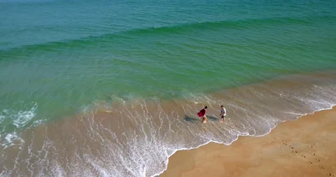 Couple Walking on Beach and Waves, Overhead Aerial Drone 4K Cinematic Stock Footage 141557908