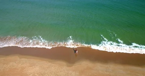 Couple Walking on Beach and Waves, Overhead Aerial Drone 4K Cinematic Stock Footage 141558046