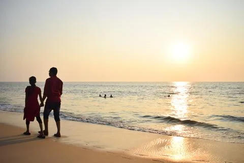 Couple walking at beach in the evening Stock Photos