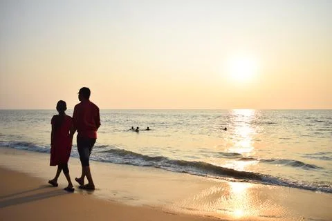 Couple walking at beach in the evening Stock Photos