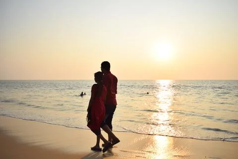 Couple walking at beach in the evening Stock Photos