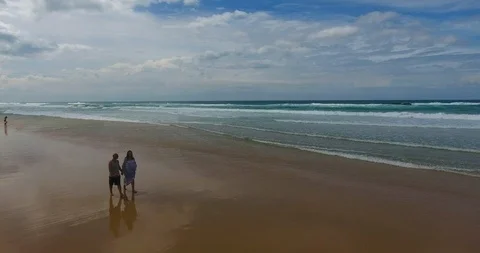Couple walking on beach heading towards camera aerial view Video stock 87698758
