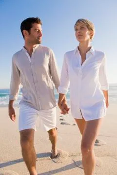 Couple walking on the beach Stock Photos