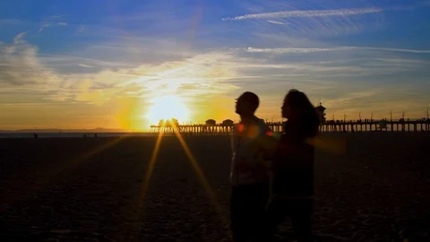Couple walking on beach at sunset, 4K Stock Footage 101002314