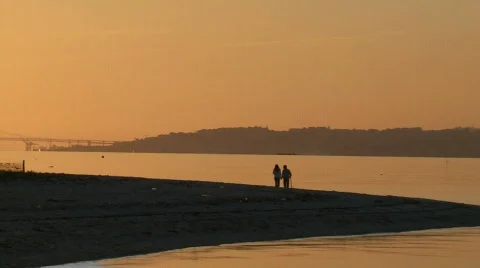 Couple walking on beach at sunset Stock Footage 100590