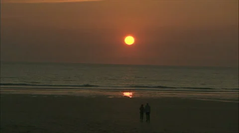 Couple Walking on a Beach at Sunset Video stock 37707688