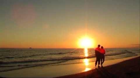 Couple walking on beach at sunset Stock Footage 43689349