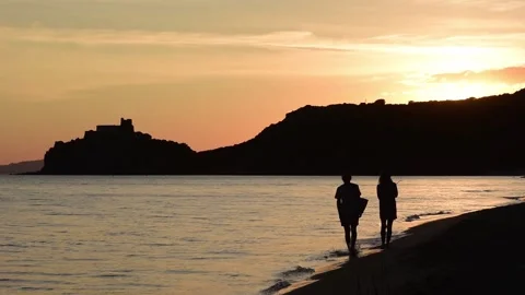 Couple walking on the beach at sunset Stock Footage 132460977