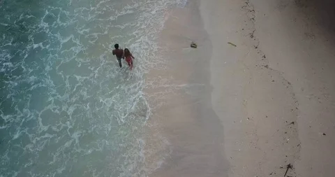 Couple Walking on Beach Top Down Drone Shot Stock Footage 106236582