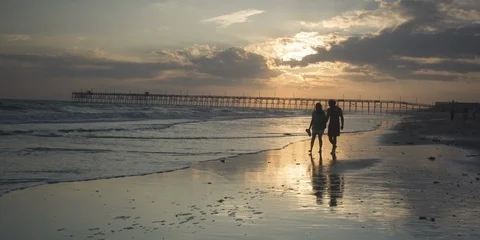 Couple walking on the breach at sunset Stock Footage 103492217