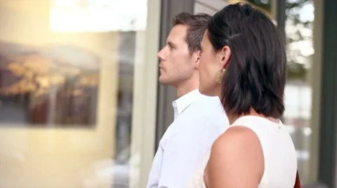A couple walking in the city stops to window shop during the day Stock Footage 48888498