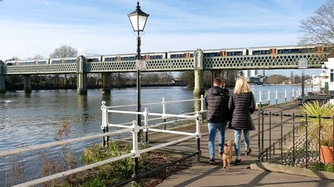 Couple walking dog on Thames Path in Chiswick Stock-Footage 123079811