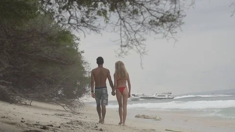 Couple Walking Down the Beach Slow Motion Stock Footage 106781581
