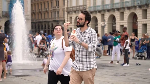 A couple is walking down the street while him is eating Amsterdam chips Stock Footage 111877598