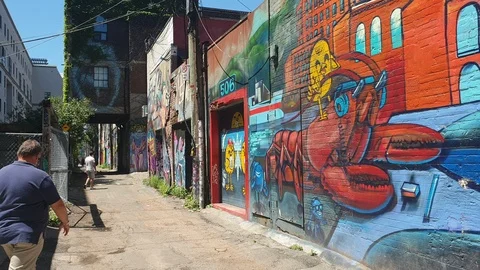 Couple walking down Toronto, Canada alleyway with urban graffiti Vídeo Stock 116137143