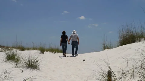 Couple Walking Up Dunes Stock-Footage 5504602