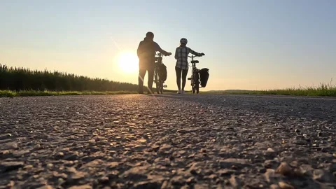 Couple Walking with E-Bikes at Sunset on  Road Stock Footage 334063435