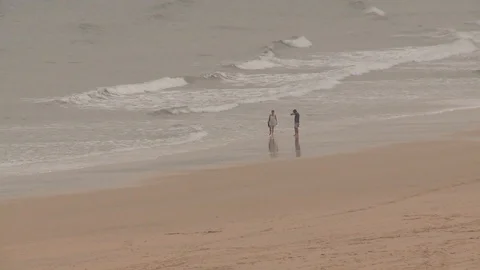 Couple walking on an empty beach Stock Footage 93781204