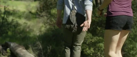 Couple walking on a fallen tree trunk the in forest Stock Footage 69199261