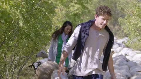 Couple walking with flock of sheeps Video stock 235393534