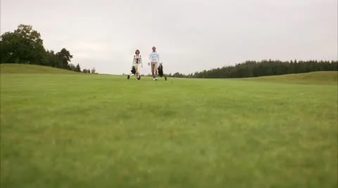 A couple walking on a golf course Stock Footage 11310821