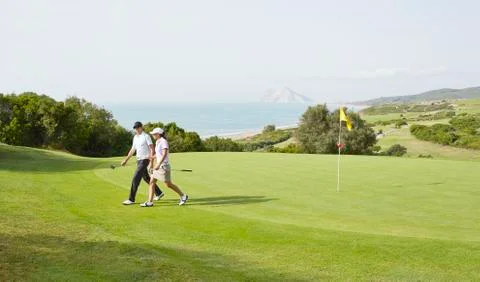 Couple walking on golf course Fotos de archivo
