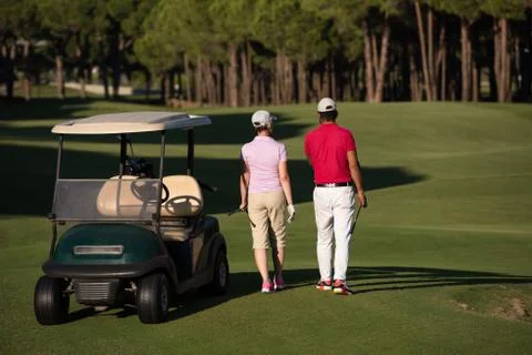 Couple walking on golf course Fotos Stock