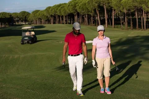 Couple walking on golf course Fotos de archivo
