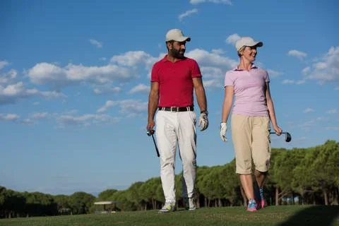 Couple walking on golf course Fotos de archivo