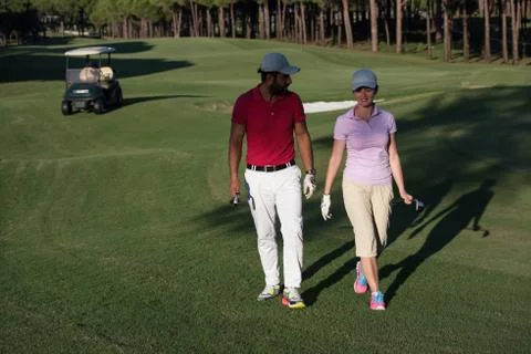 Couple walking on golf course Fotos de archivo