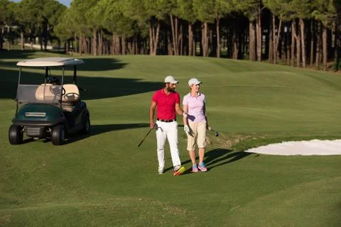 Couple walking on golf course Fotos Stock