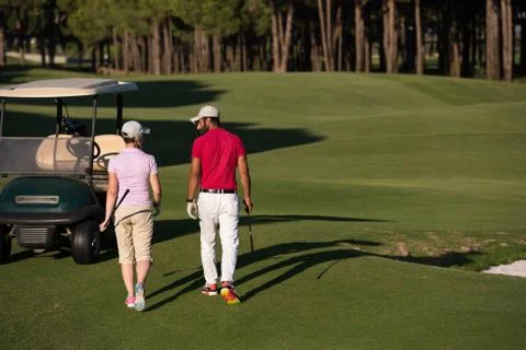 Couple walking on golf course Fotos Stock