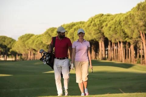 Couple walking on golf course Fotos de archivo