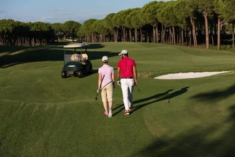 Couple walking on golf course Fotos Stock