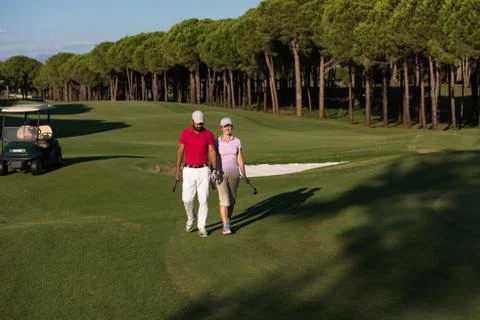 Couple walking on golf course Fotos de archivo