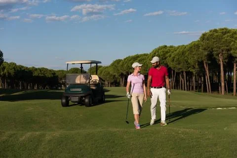 Couple walking on golf course Fotos Stock