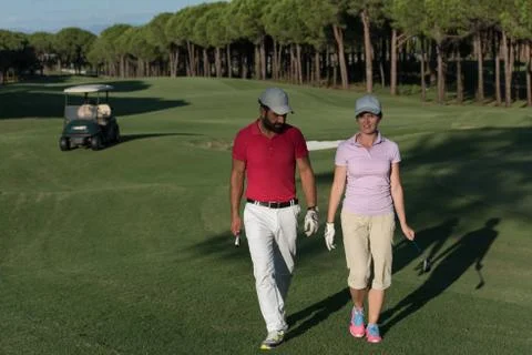 Couple walking on golf course Fotos de archivo