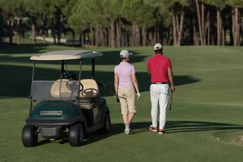 Couple walking on golf course Fotos de archivo