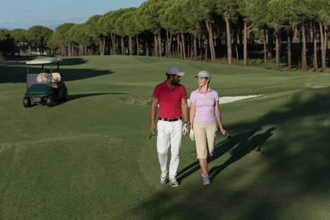 Couple walking on golf course Fotos de archivo