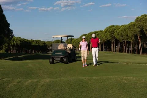 Couple walking on golf course Fotos de archivo