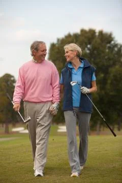 Couple walking on golf course Fotos Stock