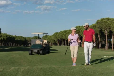 Couple walking on golf course Fotos Stock