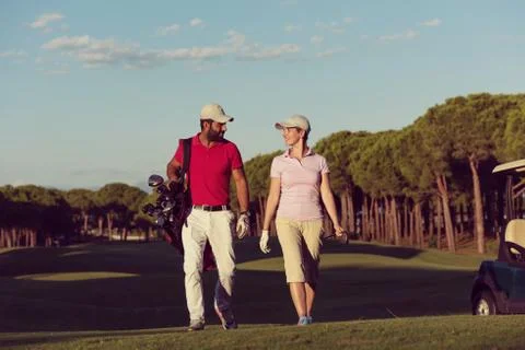 Couple walking on golf course Fotos Stock