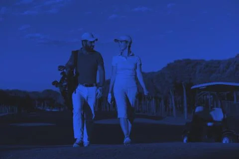 Couple walking on golf course Fotos Stock