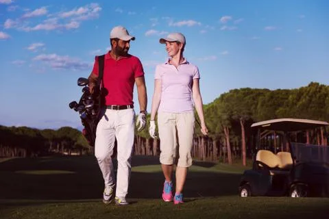 Couple walking on golf course Fotos de archivo