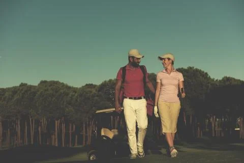 Couple walking on golf course Fotos Stock
